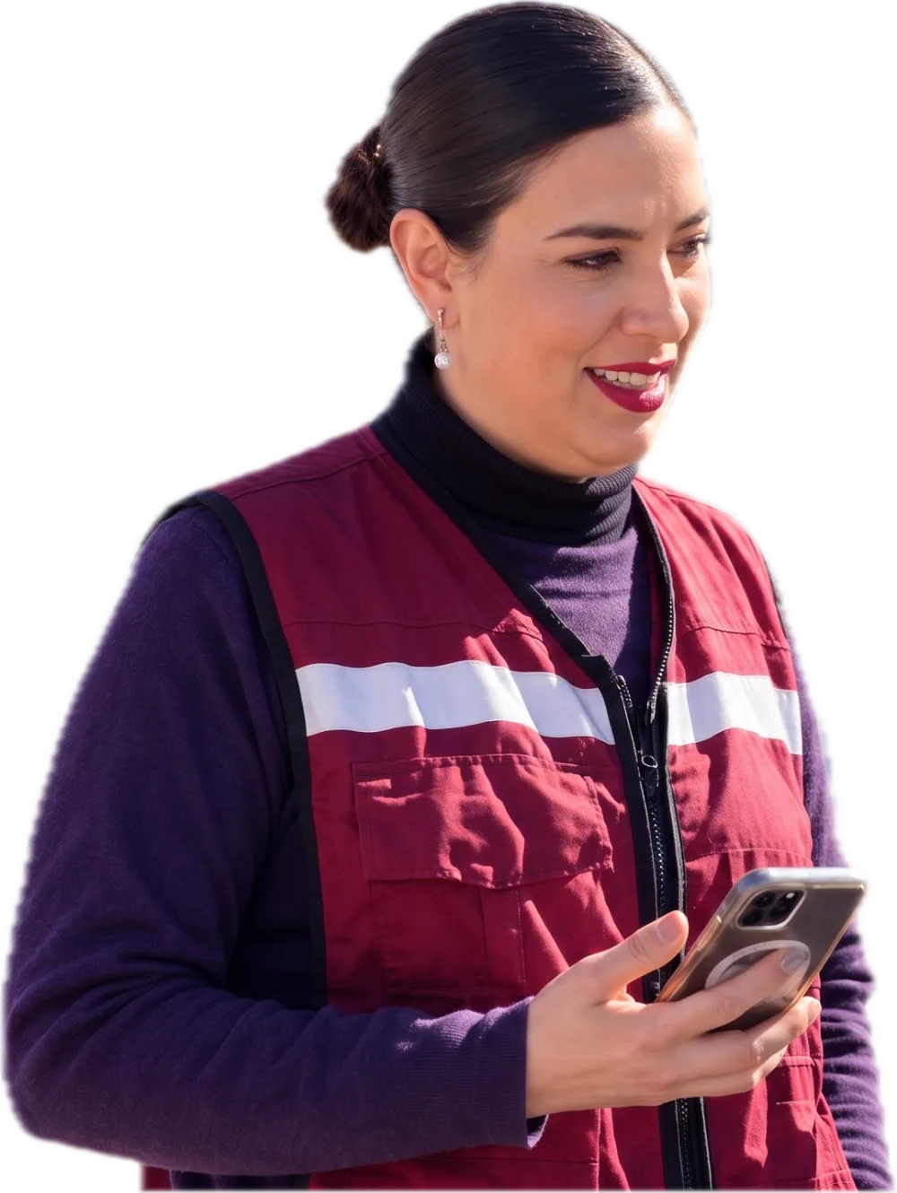 Cristy Licón con chaleco guinda, sonriendo mientras revisa su teléfono